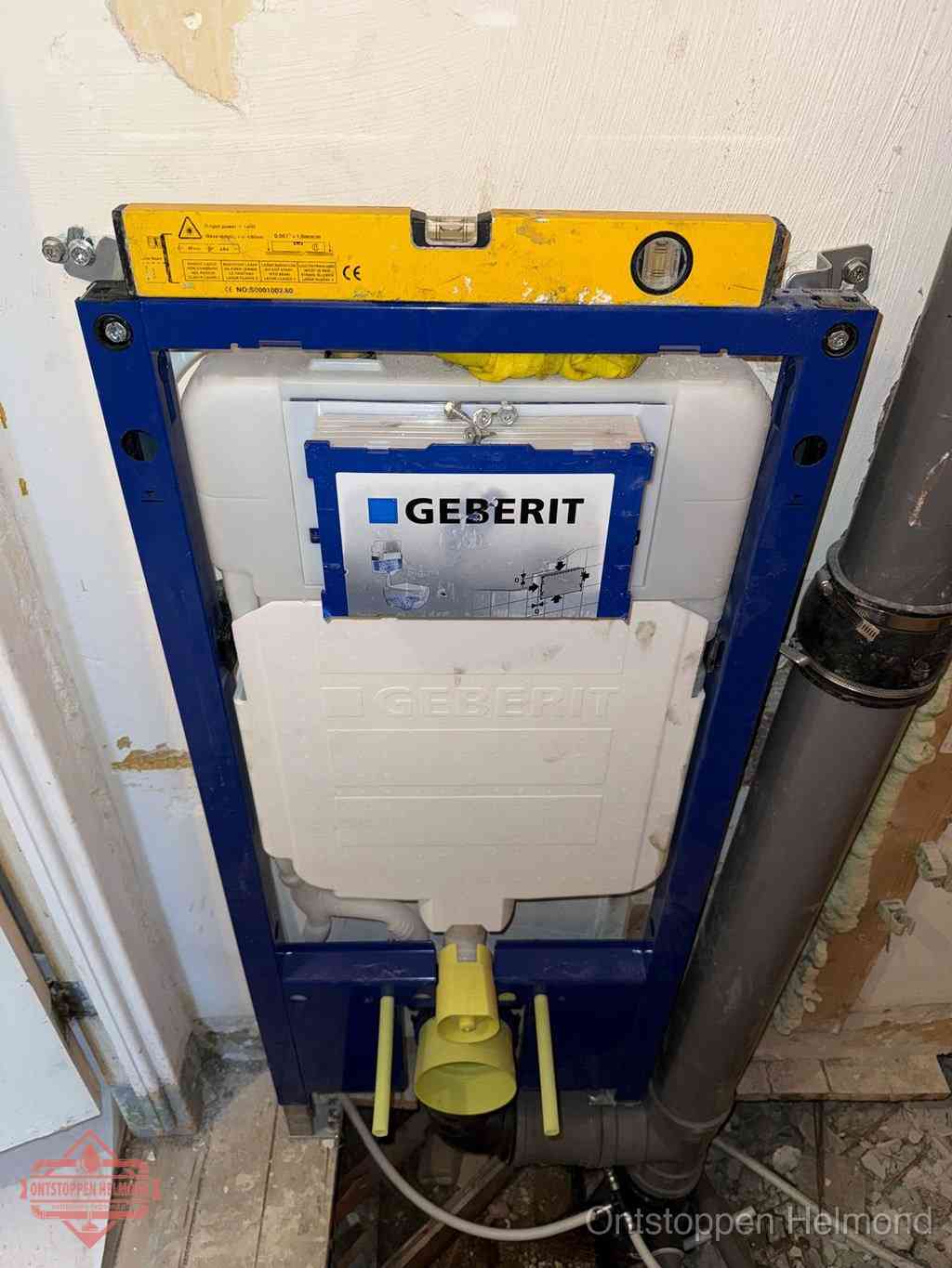 Een Geberit inbouwreservoir met frame voor een hangtoilet tegen de wand, met de afvoerbocht naar de vloer, kenmerkend voor een verstopt hangtoilet in Helmond