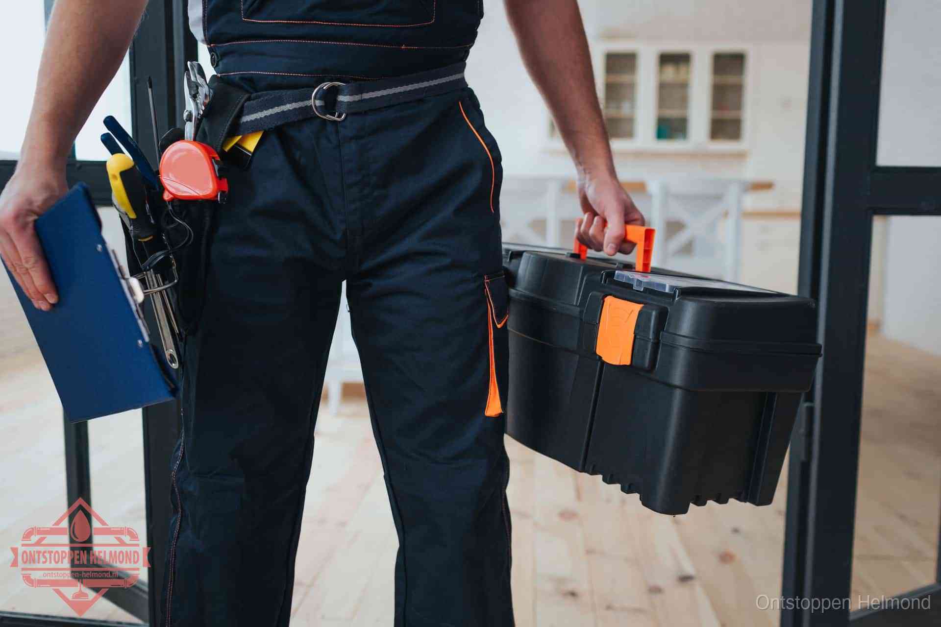 Een monteur met gereedschapsriem en klembord in een keuken, klaar om een transparante prijs voor het gootsteen ontstoppen in Helmond te geven