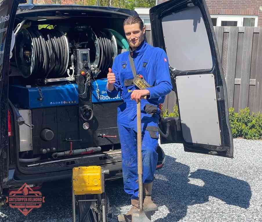 Monteur met duim omhoog bij de rioolreinigingsbus, duidelijke kosten voor riool ontstoppen in Helmond