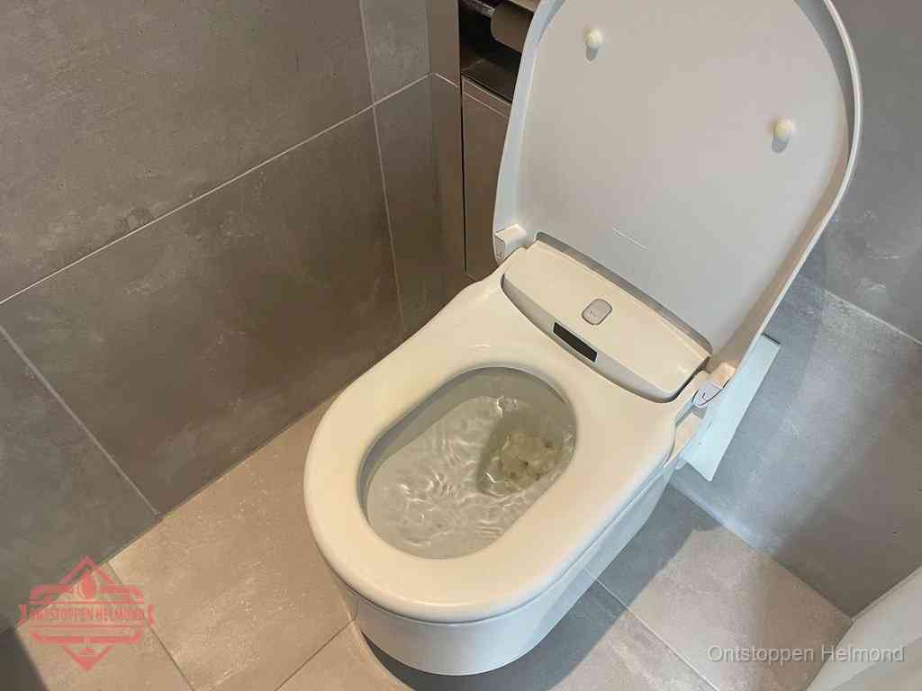 Een toiletpot vol troebel water met drijvend papier en restanten, de meest voorkomende oorzaak van een verstopte wc in Helmond