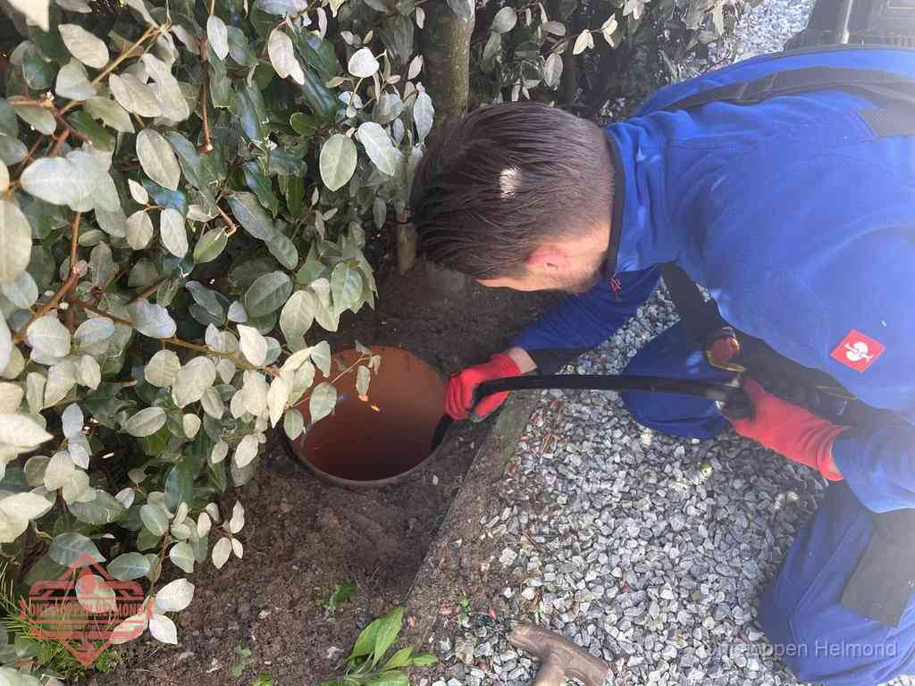 Monteur reinigt een rioolput met een slang, periodieke rioolreiniging in Helmond