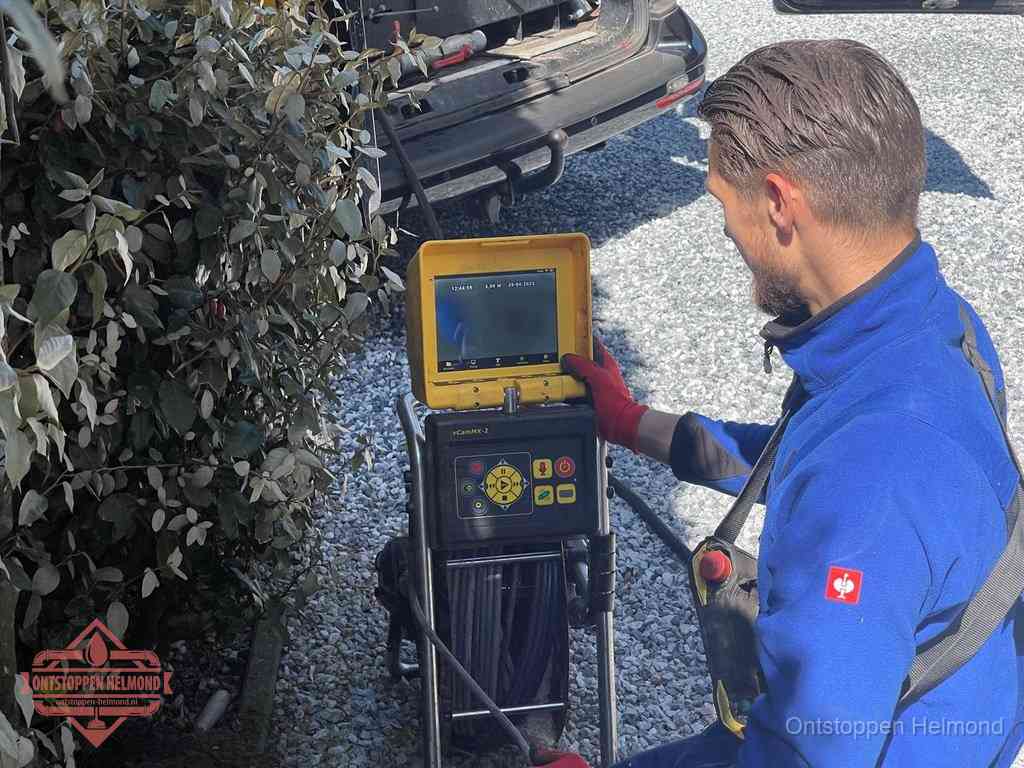 Monteur bedient een rioolinspectiecamera met monitor voor rioolinspectie in Helmond
