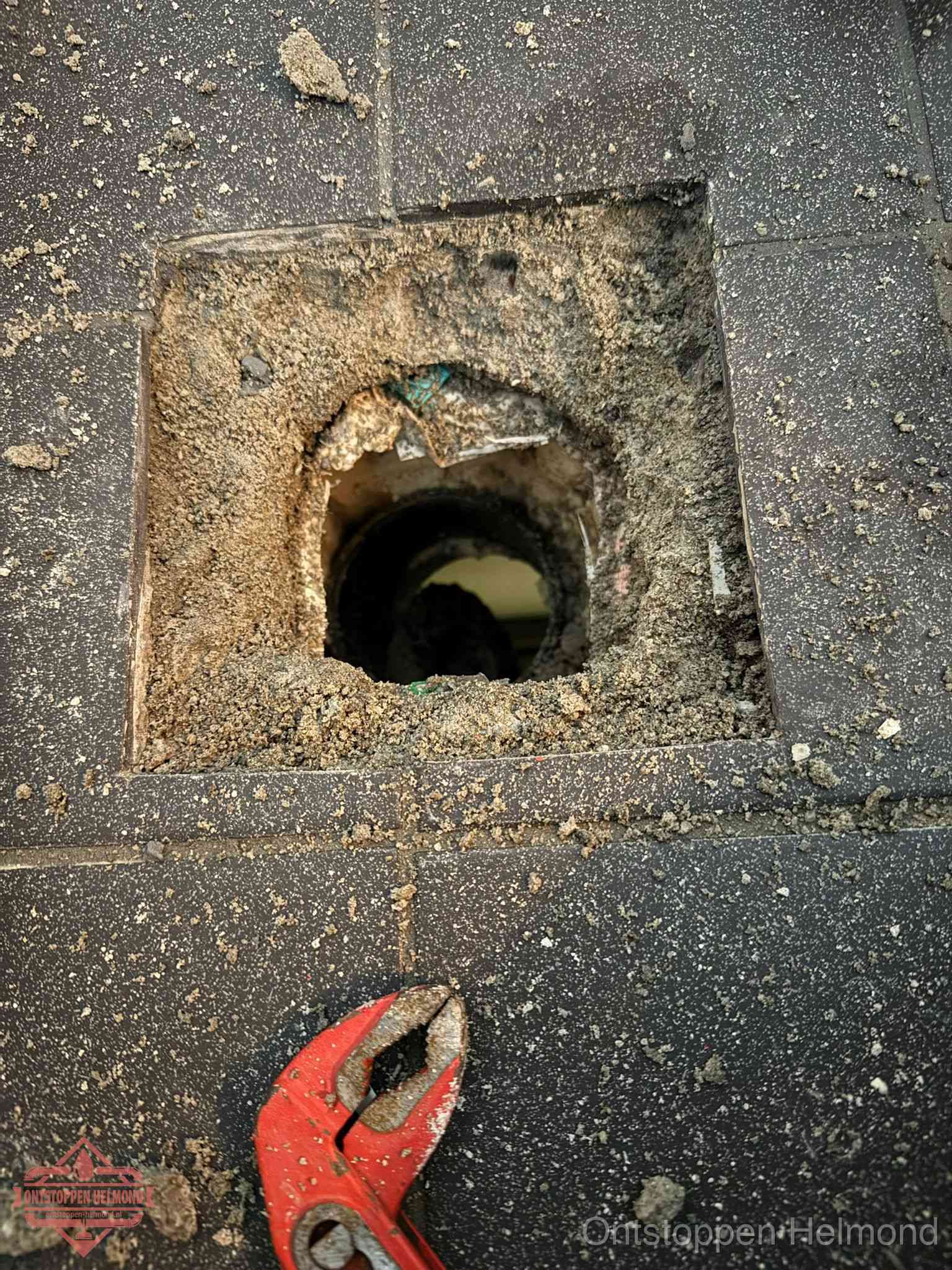 Geopend rioolputje op de erfgrens dat laat zien wie eigenaar is van de riolering in Helmond