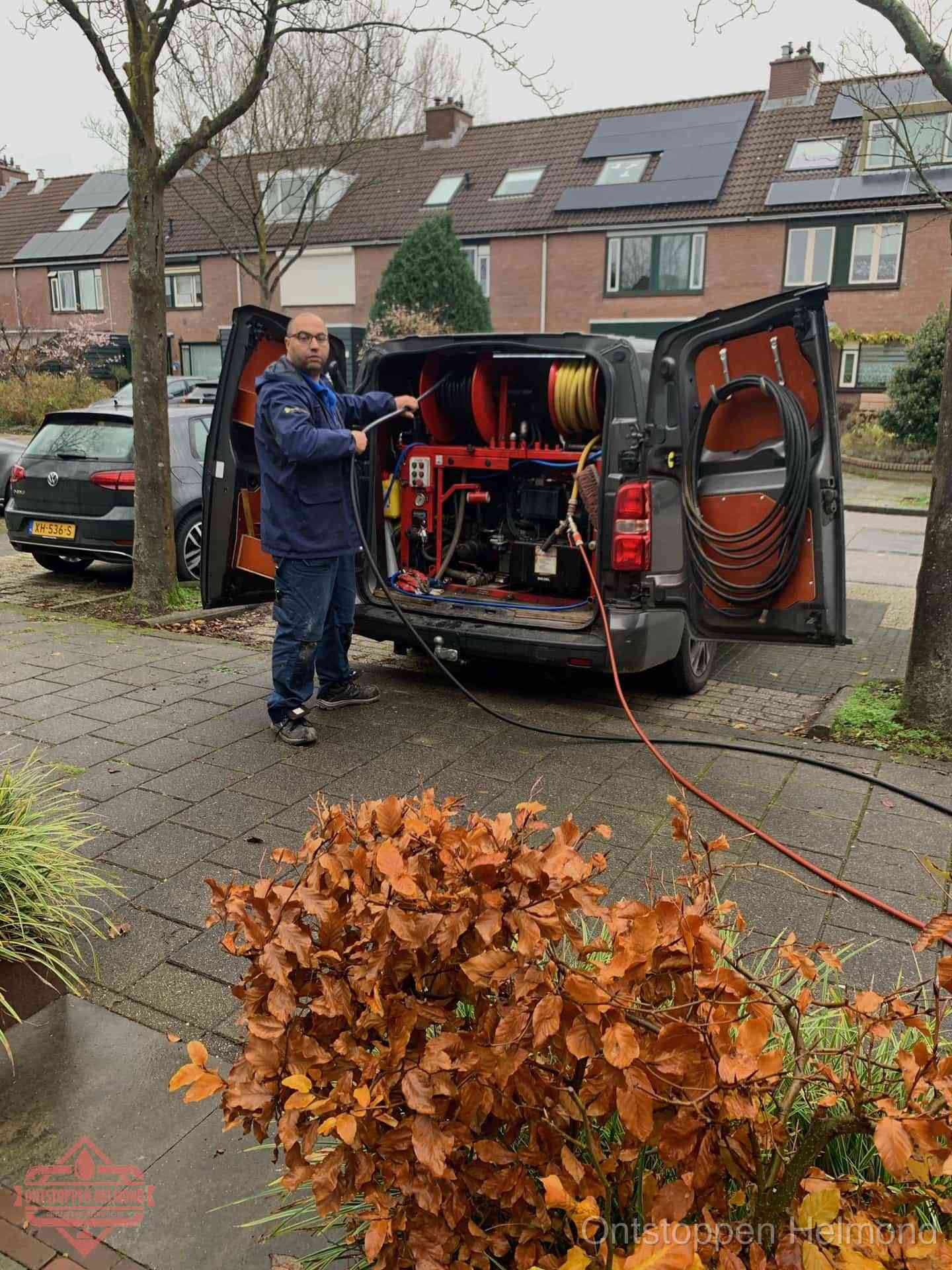 Monteur met rioolreinigingsbus levert rioolservice in de wijk in Helmond