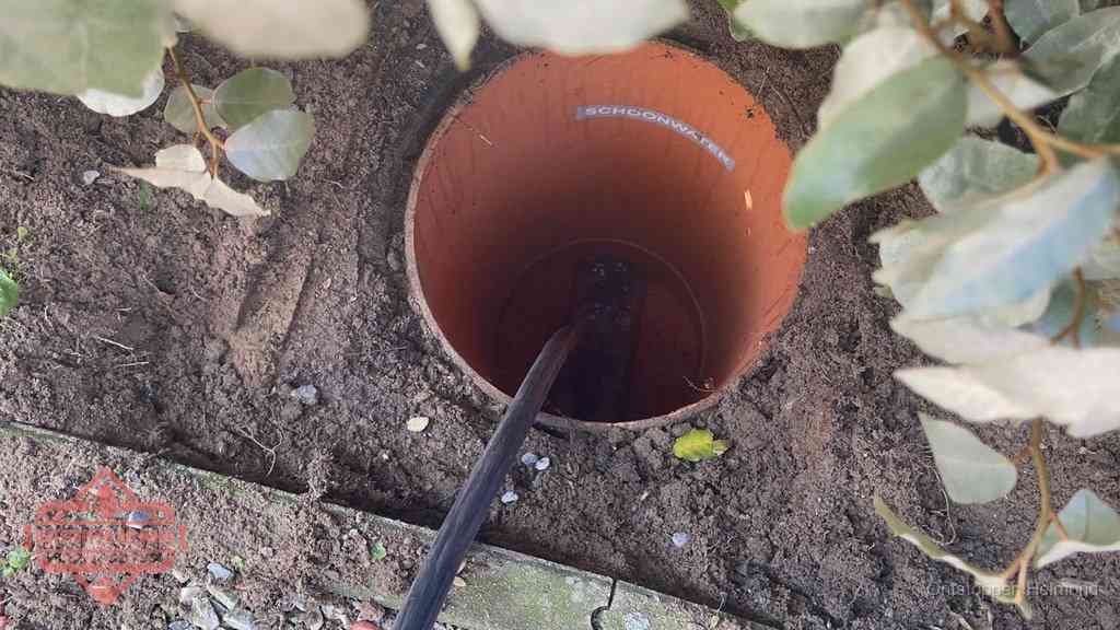 Open inspectieput in de tuin waar een veer rioolvliegjes en stankoverlast aanpakt in Helmond