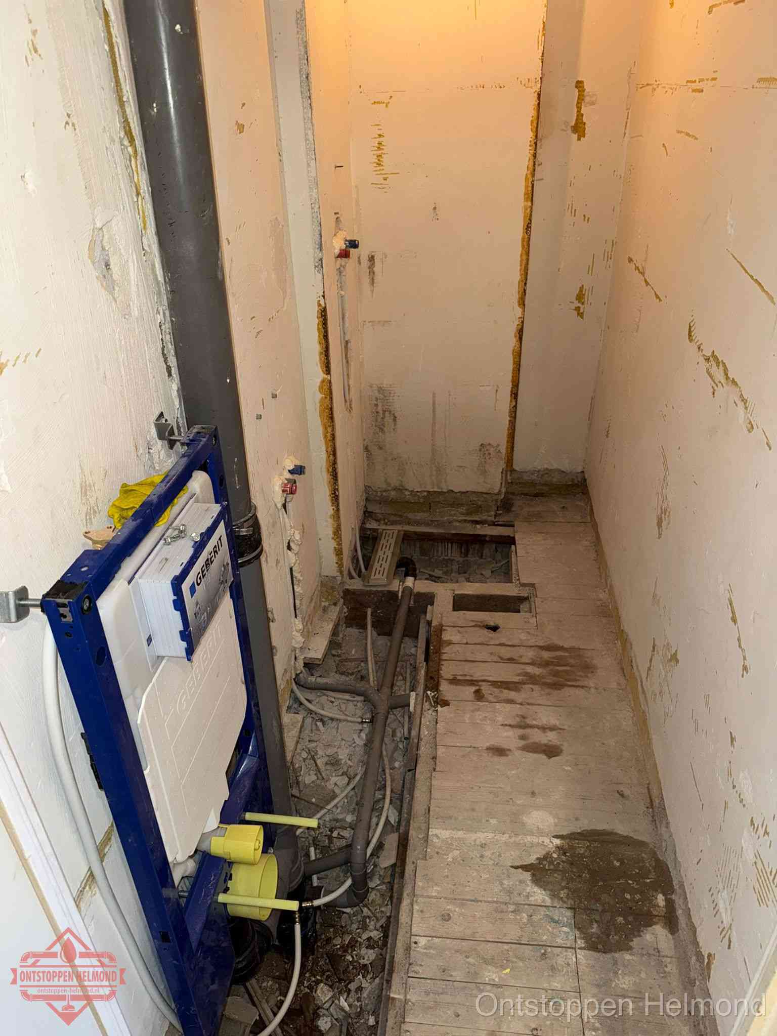 Een opgebroken toiletruimte tijdens renovatie met een Geberit inbouwreservoir en blootliggende oude afvoerleidingen, typisch voor oudere woningen in Helmond